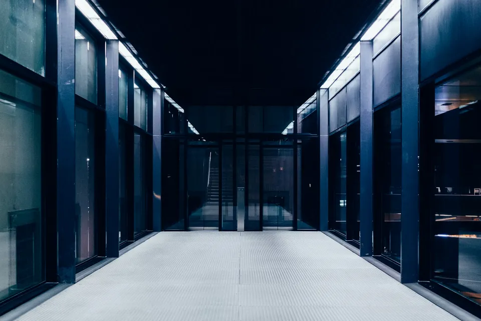 Modern dark corridor with semi-hidden server racks.
