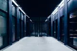 Modern dark corridor with semi-hidden server racks.