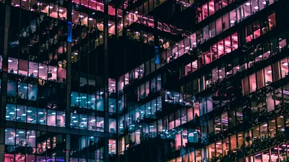 Illuminated glass office building at night.